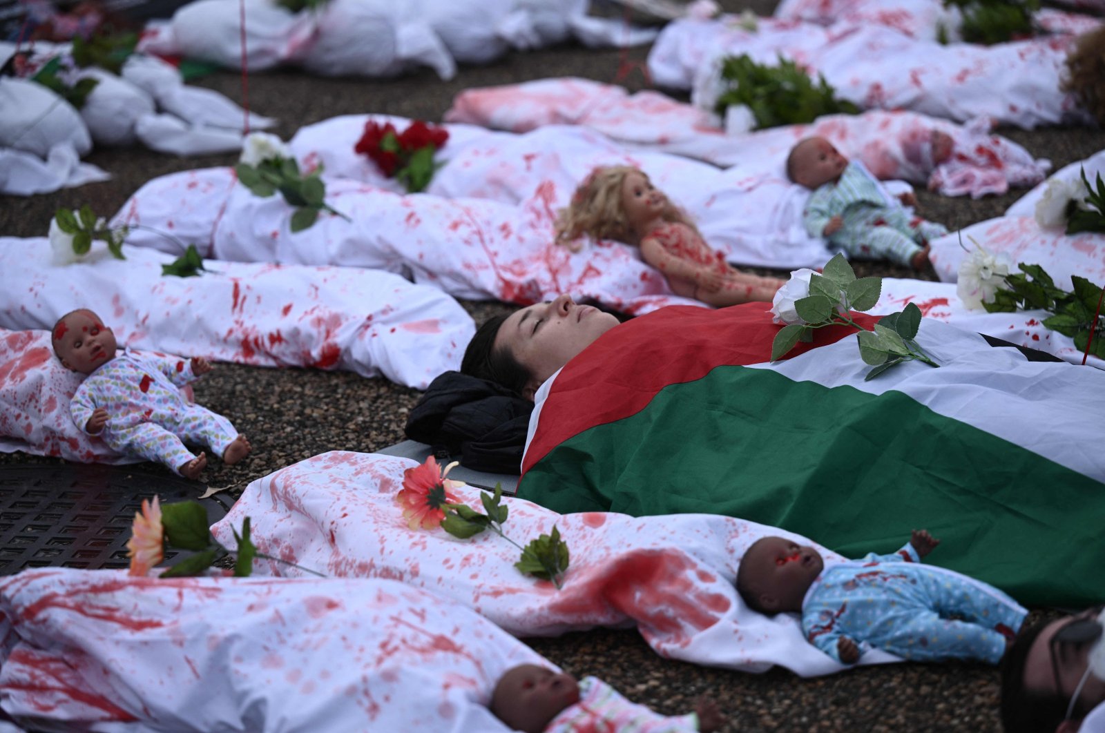 Activists representing victims in the Israel-Palestine conflict,lay on the ground in front of the White House during a rally in support of Palestinians in Washington,DC,Dec. 2,2023.(AFP Photo)